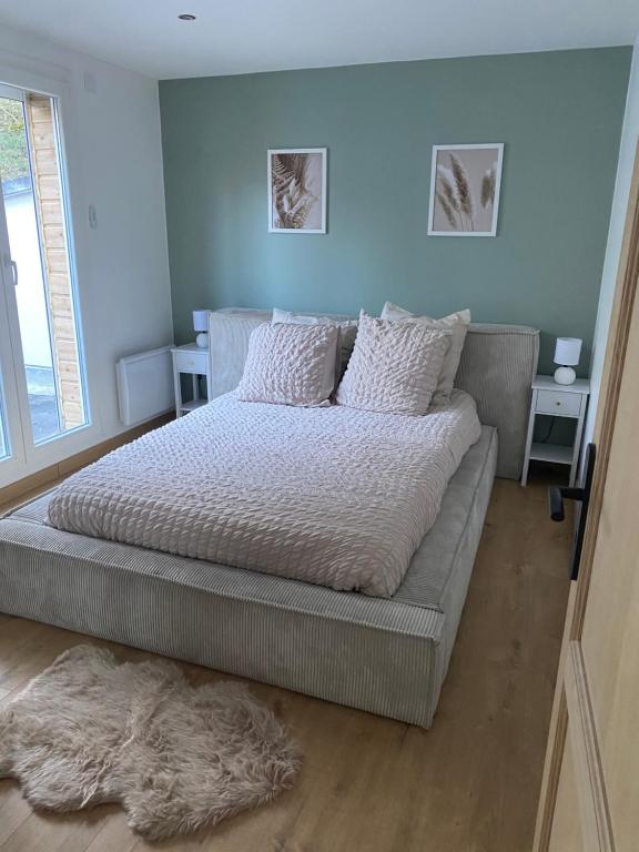 1 dormitorio con 1 cama grande con sábanas y almohadas blancas en Appart lac lamartine, en Aix-les-Bains