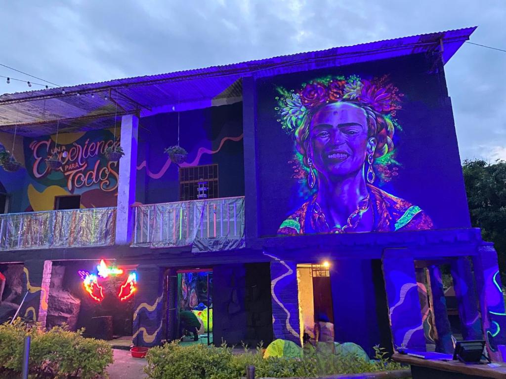 un bâtiment avec une grande peinture d'une femme sur lui dans l'établissement Color'Es Club, à El Colegio
