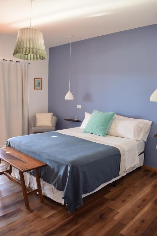 ein Schlafzimmer mit einem großen Bett mit einer blauen Decke in der Unterkunft Villa Mendotza in Ciudad Lujan de Cuyo