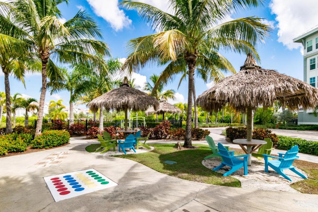 a patio with chairs and umbrellas and palm trees at One Particular Harbour 387-101 in Bradenton