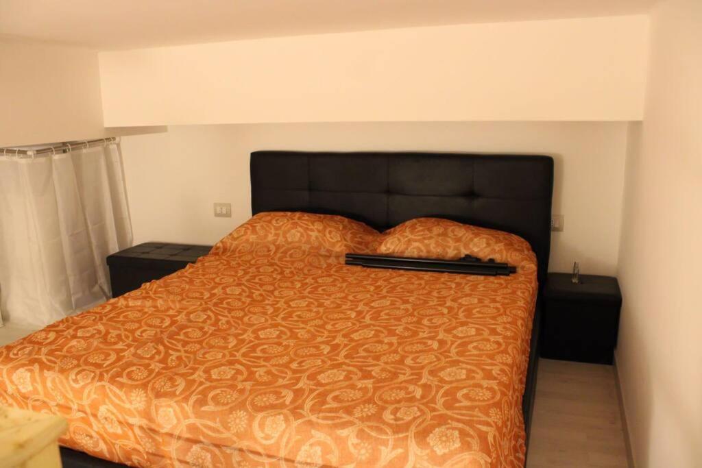 a bed with a black headboard in a bedroom at 4 posti letto vicino pala alpitour! in Turin