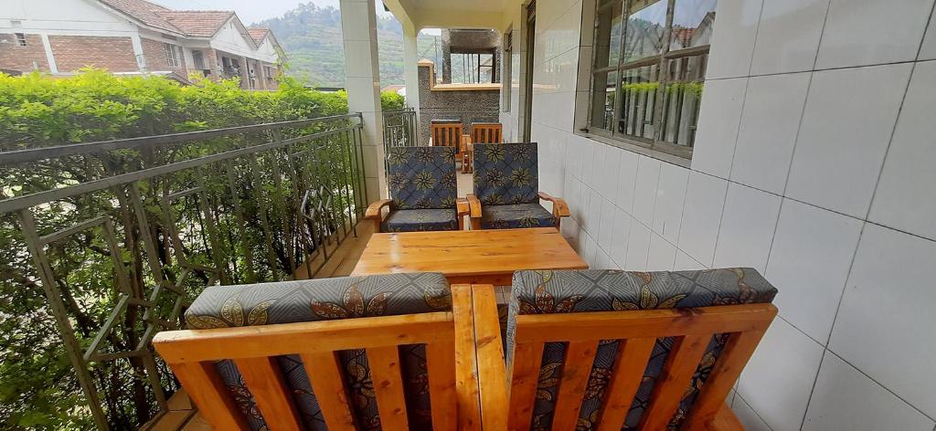 - une terrasse couverte avec 2 chaises et une table sur un balcon dans l'établissement SAWA SAWA GUEST HOUSE, à Kisoro