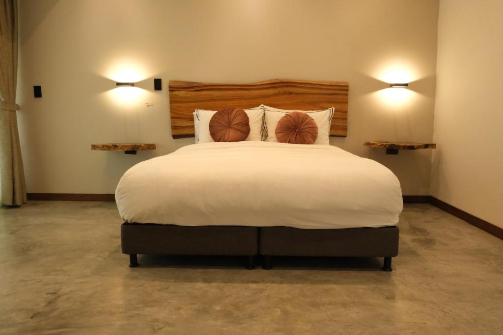um quarto com uma grande cama branca e 2 almofadas em UKO Urban Ekolodge em Armênia
