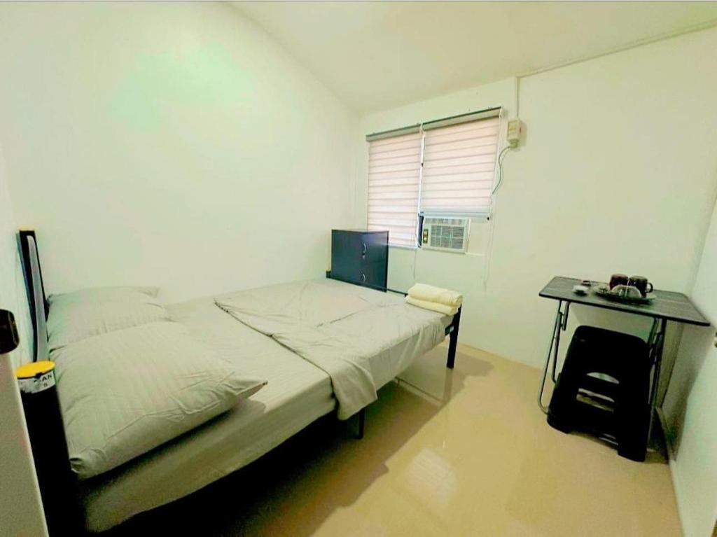 a small bedroom with a bed and a desk at Bachelorette Rental in Ormoc