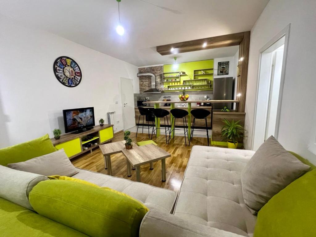 a living room with a couch and a kitchen at Green Apartment in Skopje