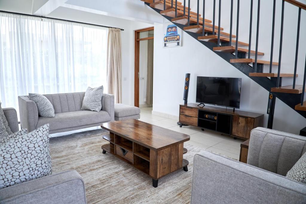 a living room with a couch and a tv at Monarch Villas - Kilifi in Vipingo