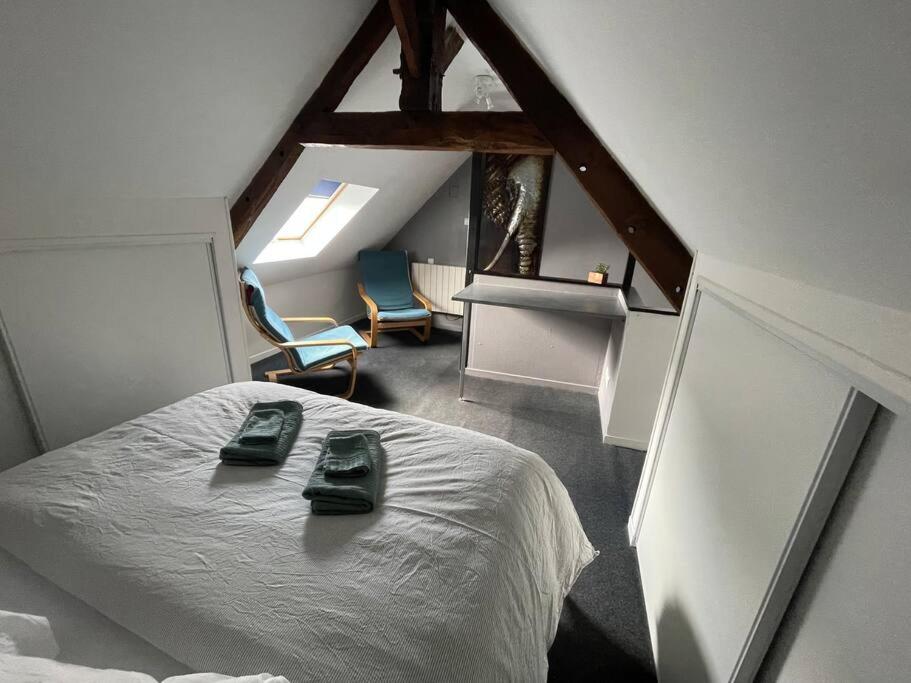 Cottage including secret garden في La Trinité-Porhoët: غرفة نوم عليها سرير وحذيين