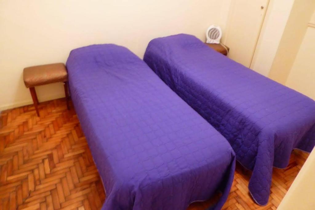 two purple beds in a room with wooden floors at Departamento 2 ambientes Centro de Mar del Plata in Mar del Plata