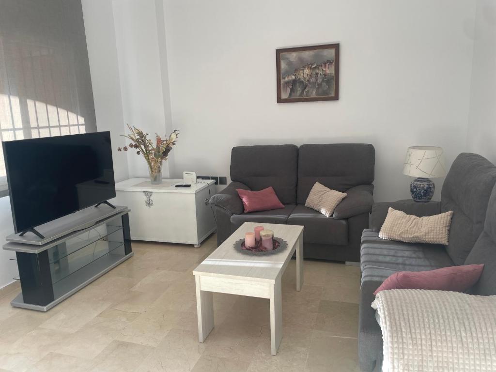 a living room with a couch and a tv at Novo Atlantico Golf 7 in Novo Sancti Petri