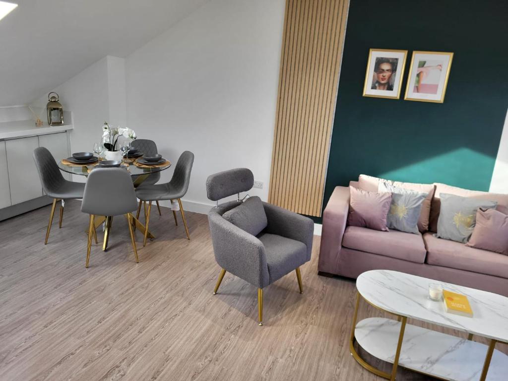 ein Wohnzimmer mit einem Sofa und einem Tisch mit Stühlen in der Unterkunft 20 mins to central London, Stylish sky views 2 bed in London