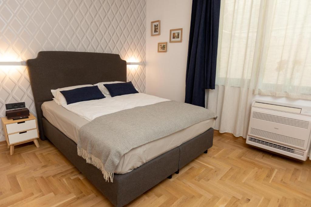 a bedroom with a large bed with blue pillows at Luxury rooms 12-1 in Plovdiv