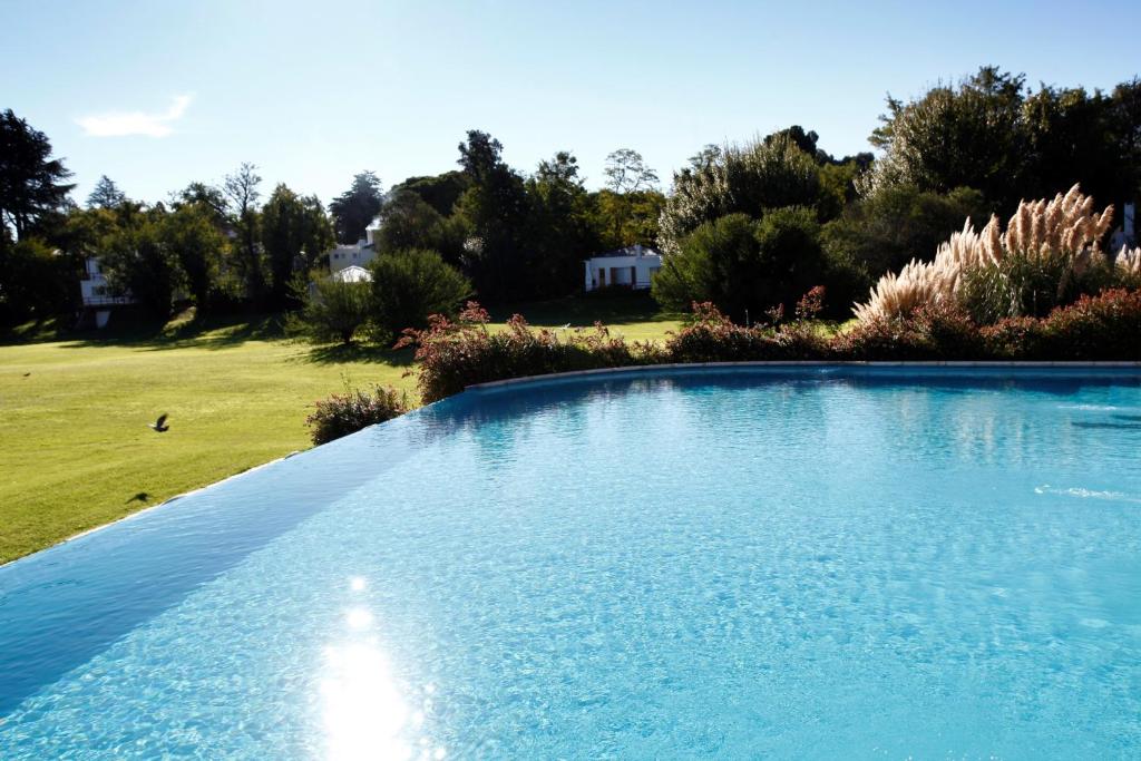una gran piscina con agua azul en un patio en Acacias Country Club en Sierra de la Ventana