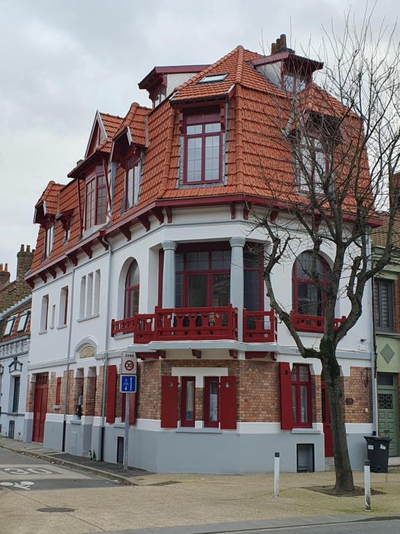 a white and red building with a red roof at Les Iris, Malo les bains, 350 m de la plage in Dunkerque