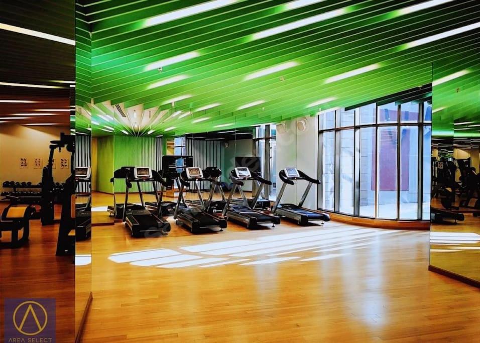 une salle de sport avec plusieurs tapis de course et un plafond vert dans l'établissement Merkezi, havuzlu, lüx site içerisinde komförlü homeoffice, à Istanbul