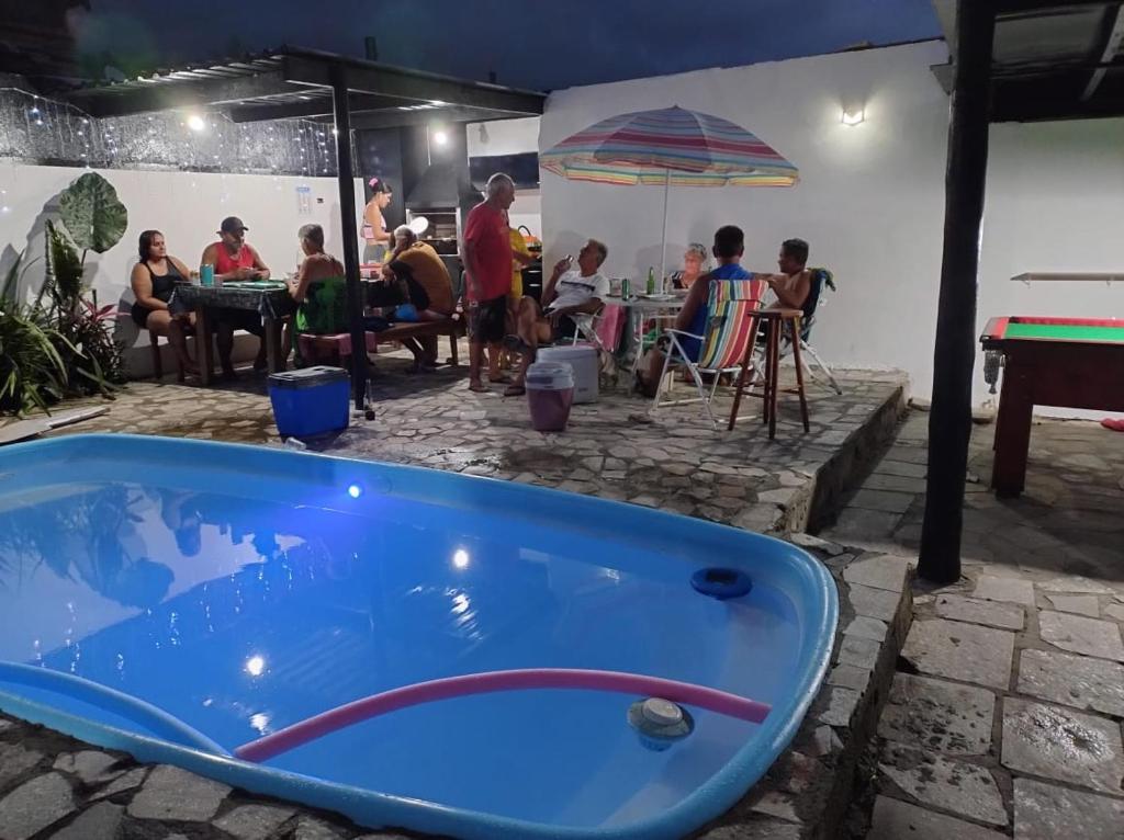 a blue tub in a patio with people sitting at tables at Praia Piscina Bilhar Churrasqueira in São Sebastião