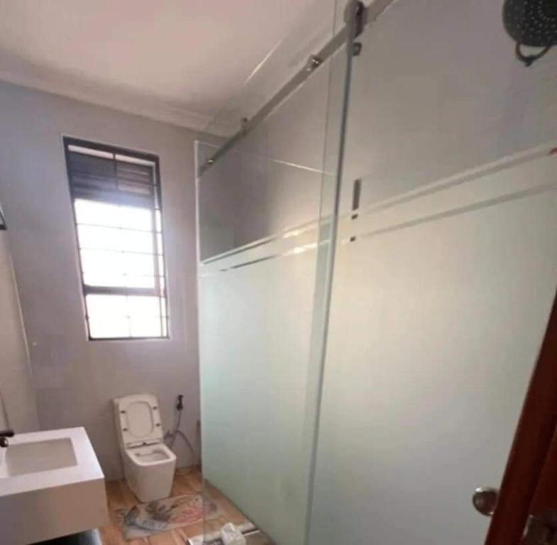 uma casa de banho com um WC e um lavatório em Nalya Apartments em Kampala