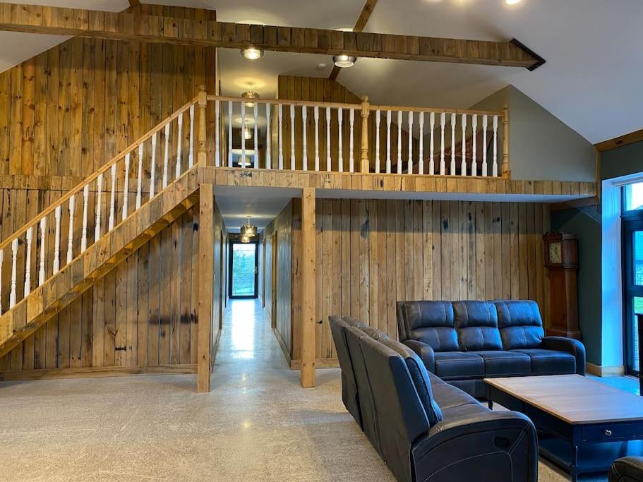 a living room with a couch and a staircase at Moig Lodge - 7 Double Bedroom Barn Conversion in Limerick