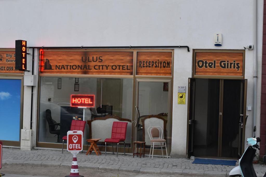 einen Laden vorne mit Stühlen und ein Schild am Fenster in der Unterkunft EDİRNE GUEST HOME HOSTEL in Edirne