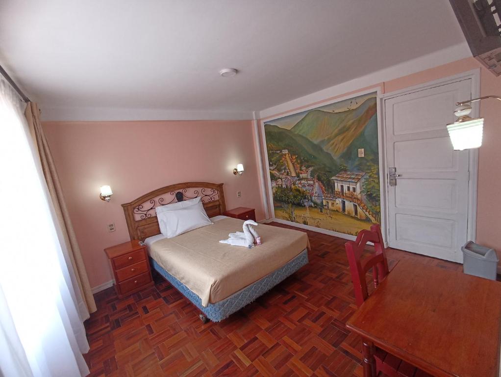 RIXAA Hotels في لاباز: غرفة نوم بسرير ودهان على الحائط