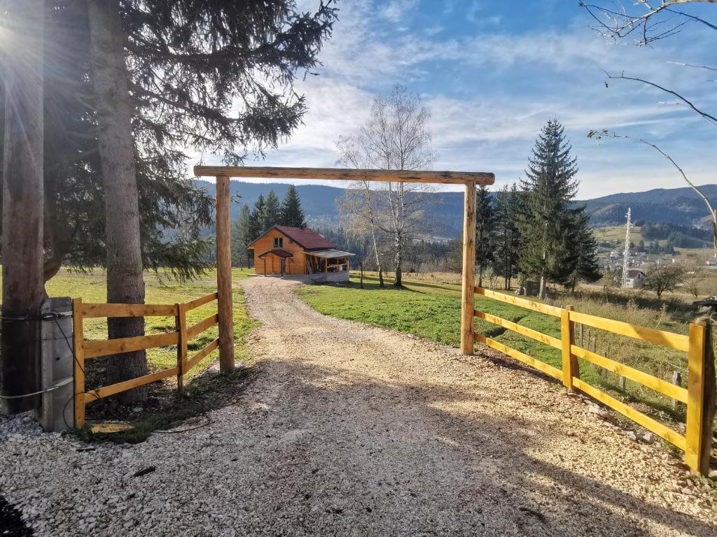 a wooden gate to a field with a barn at Brvnara Vidra in Pale