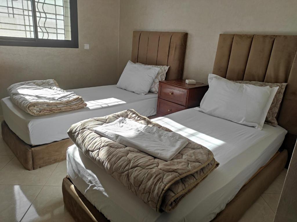 two twin beds in a room with at Your Airport Oasis Resort 15 Minutes from Rabat in Sale