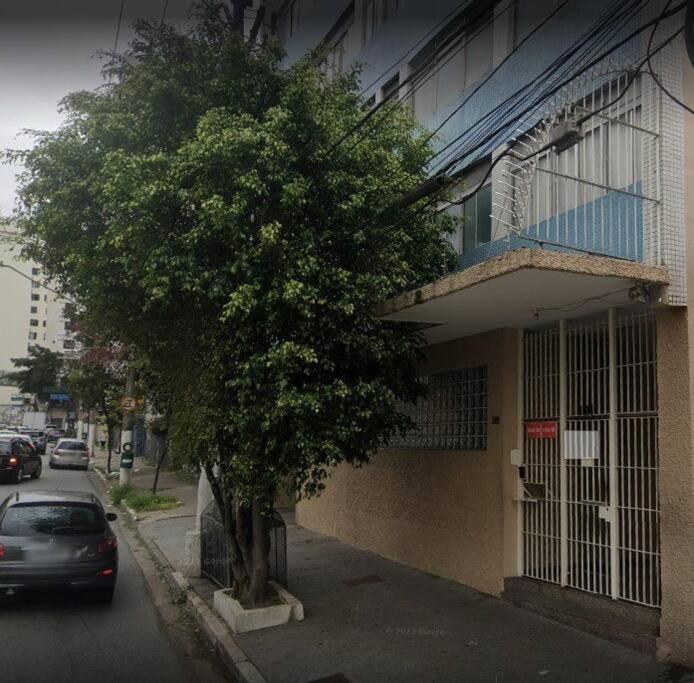 um carro estacionado ao lado de uma árvore ao lado de um edifício em Studio Moderno e Aconchegante em Perdizes em São Paulo