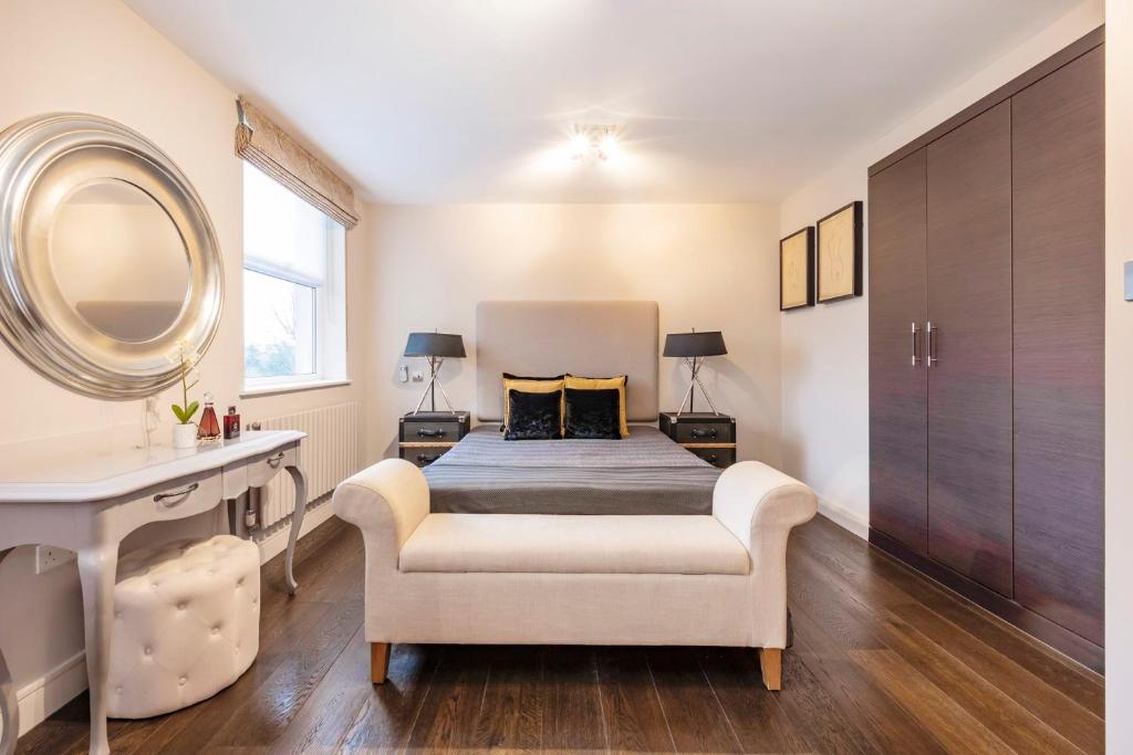 a bedroom with a bed and a mirror and a chair at CAMDEN Lux Suite-Hosted by Sweetstay in London