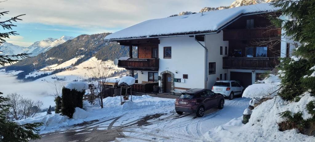 a house with a car parked in the snow at Haus Bergleiten in Alpbach