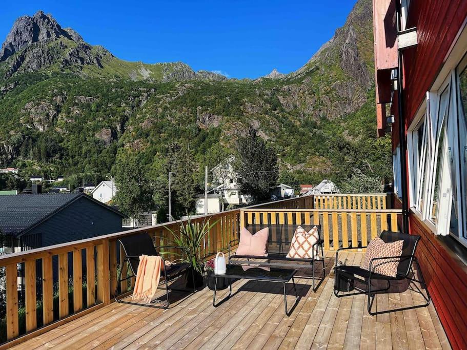 a deck with chairs and a table with a mountain at Leilighet med egen uteplass og utsikt. Parkering. in Svolvær