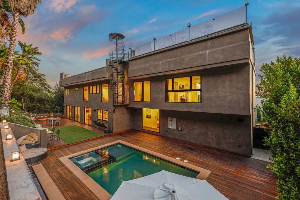 une maison avec une piscine sur une terrasse en bois dans l'établissement Luxurious Modern Mansion Hollywood Hills, à Los Angeles