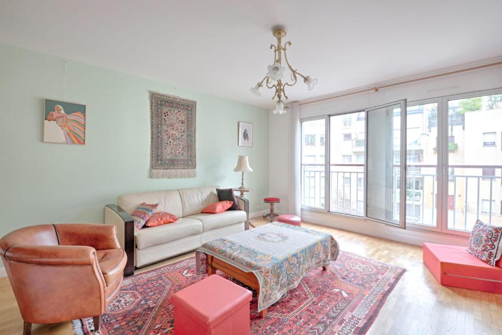 un salon avec un canapé et une chaise dans l'établissement Appartement Martino - Welkeys, à Paris