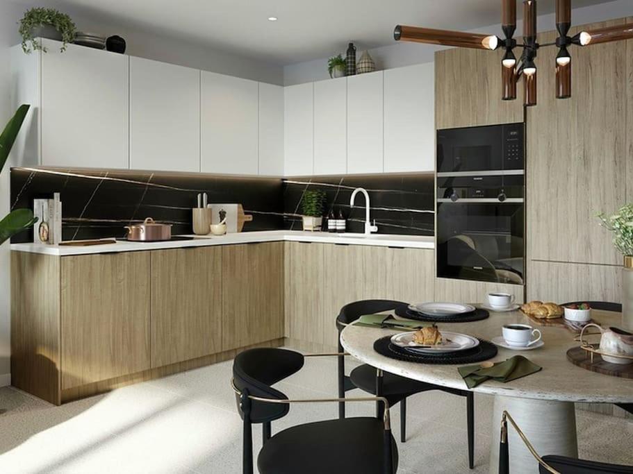 a kitchen with a table and chairs in a kitchen at Brand New 1 Bed Modern Apartment in London