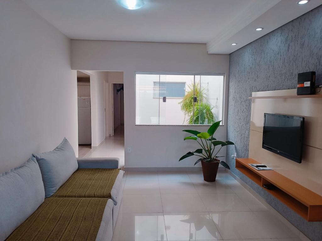 een woonkamer met een bank en een tv bij Casa de Maria in Aparecida
