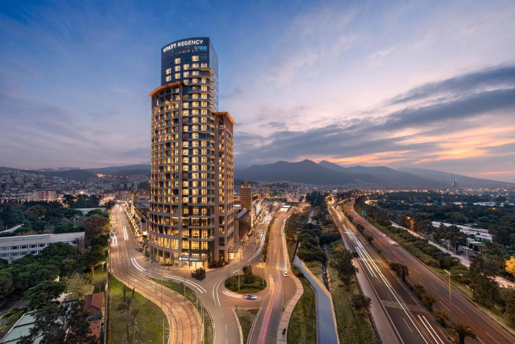 a tall building in the middle of a city at Hyatt Regency Izmir IstinyePark in Izmir