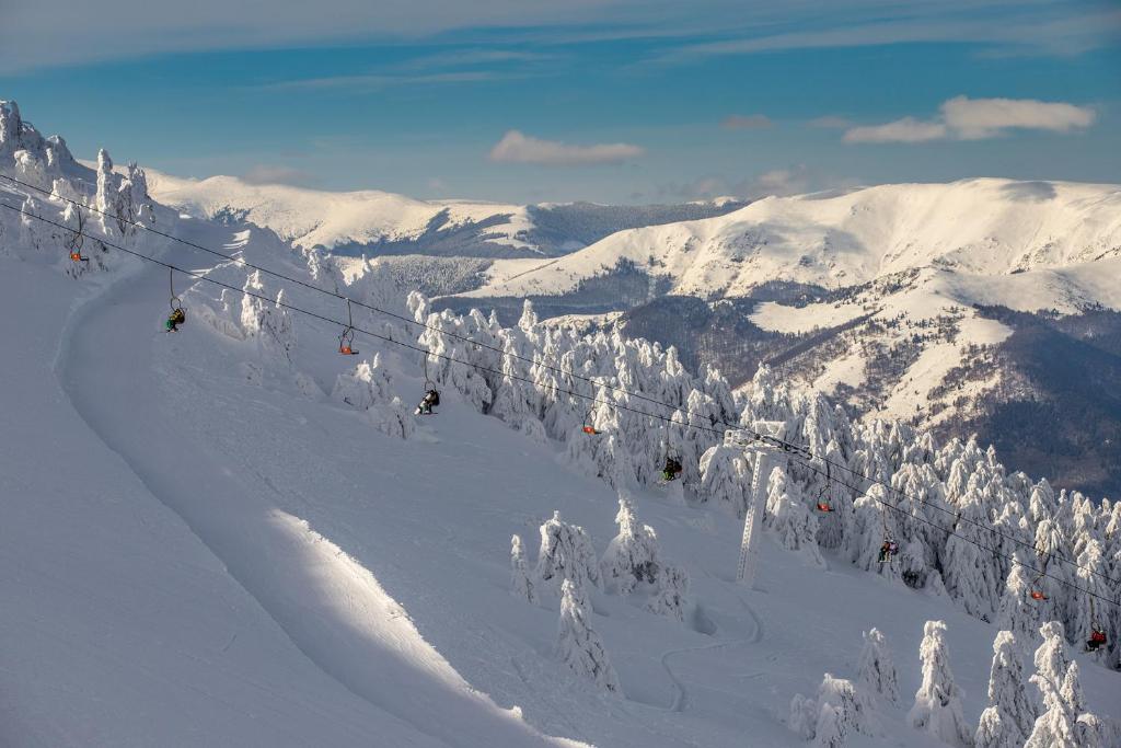 a group of people on a ski lift in the snow at Lily Ap in Lupeni