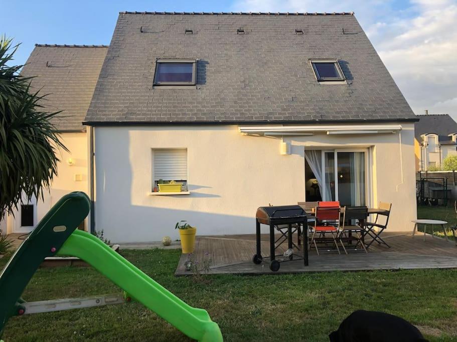 une maison avec une arrière-cour dotée d'un toboggan et d'une aire de jeux dans l'établissement Ty Gabi - Maison à 20 minutes des plages, à Landaul