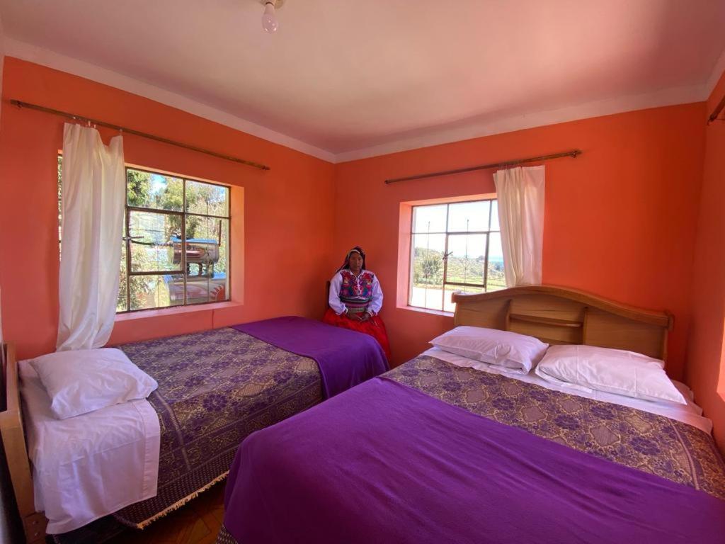 uma mulher num quarto com duas camas em Orlando´s House em Ocosuyo