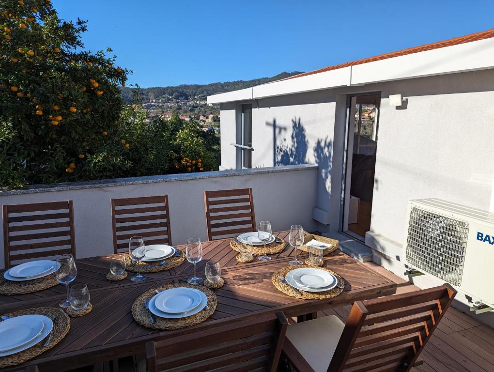 een houten tafel met borden en glazen op een balkon bij Cantinho dos Avós - Country House in Sever do Vouga