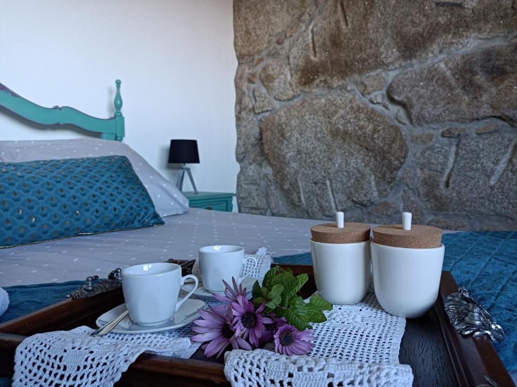 bandeja con tazas, platos y flores en una cama en Fraga`s House - Douro e Natureza en Coura