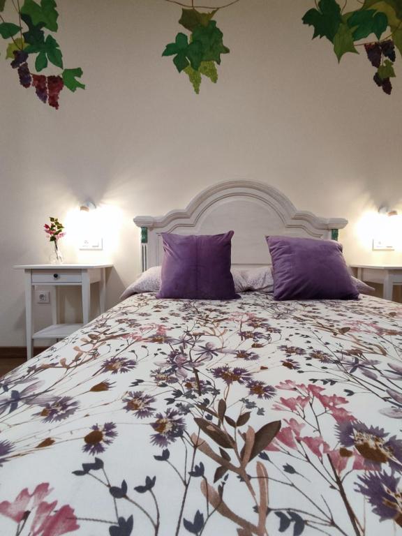 1 dormitorio con 1 cama grande con almohadas moradas en Alange Termal, en Alange