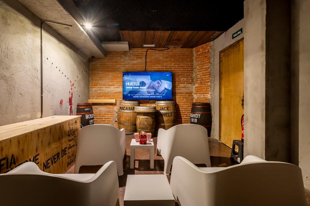 Zimmer mit Stühlen und einem Flachbild-TV in der Unterkunft NAP v in Valencia