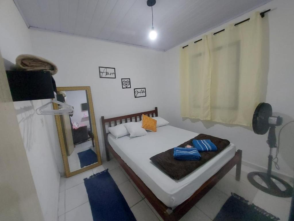 Dormitorio pequeño con cama y espejo en Lar, doce mar. en Paraty
