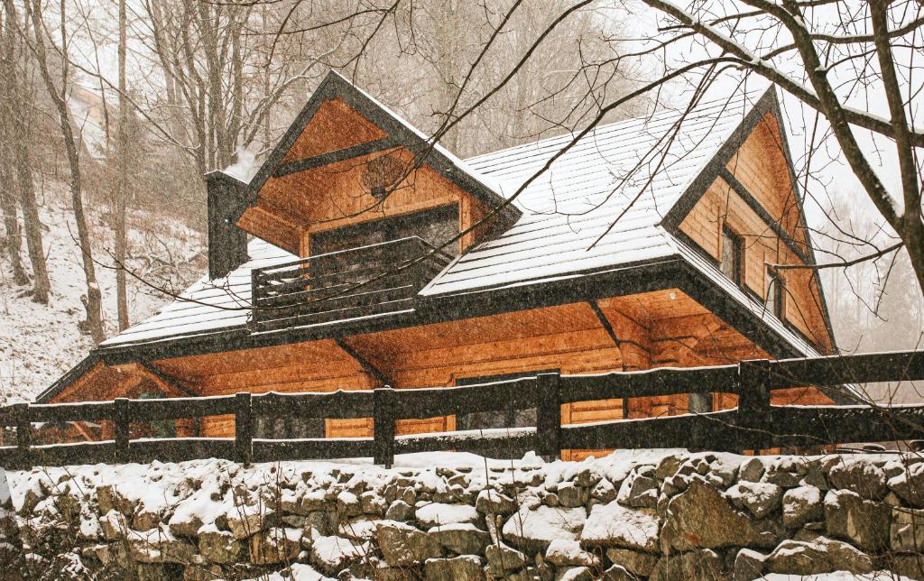 domek z bali i śniegiem na dachu w obiekcie Chata na Skarpie - SPA i widok na Skrzyczne w Szczyrku