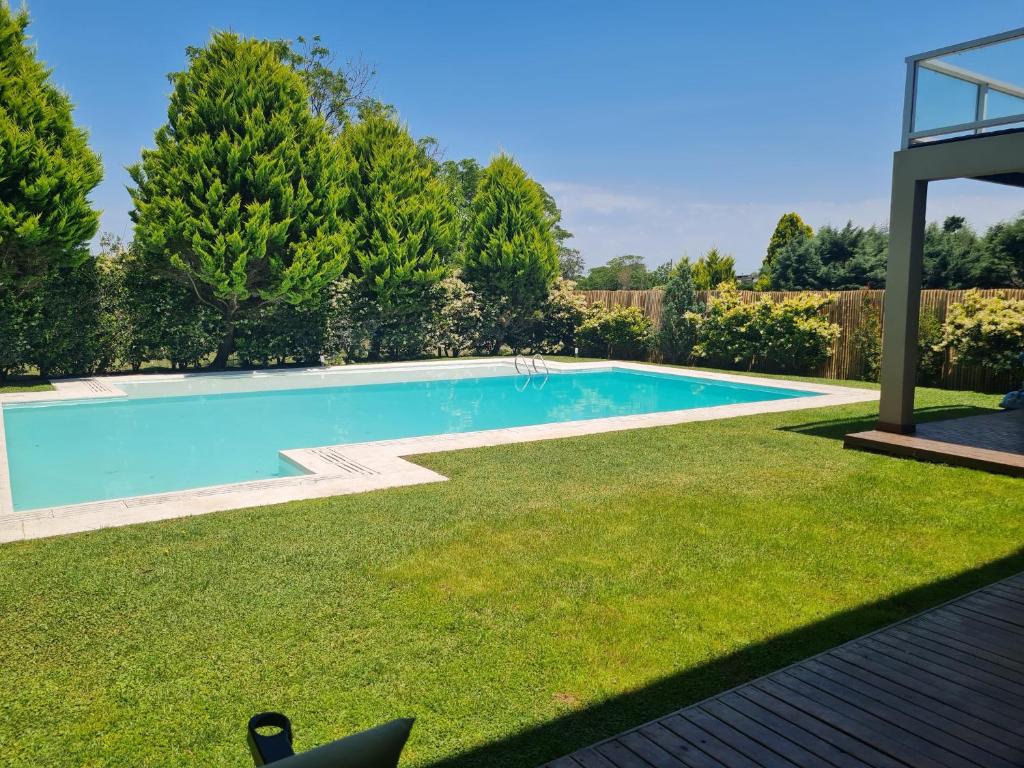 una piscina en un patio con césped y árboles en Villa de Diseño exclusivo en Belén de Escobar