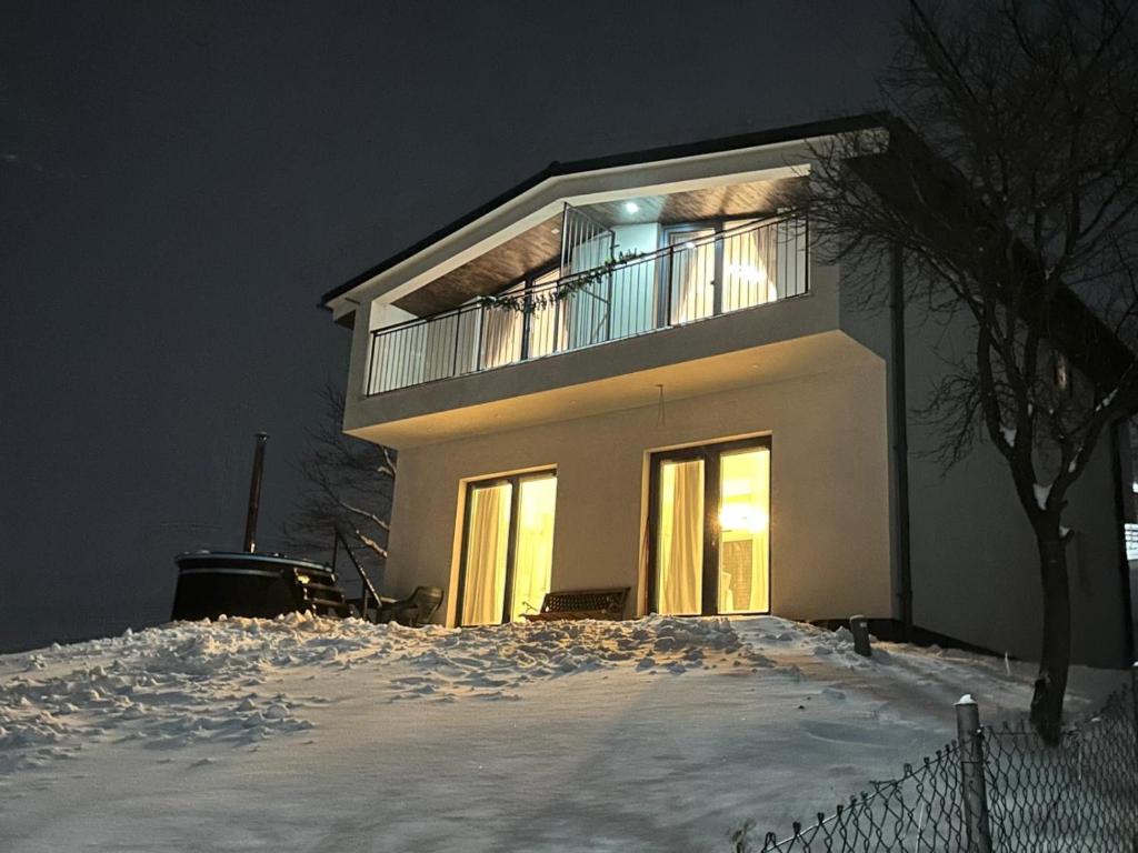 a building with a balcony on top of a snow covered yard at Vacation house in Borsa