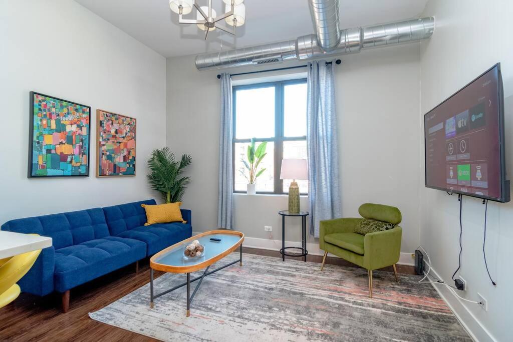 uma sala de estar com um sofá azul e uma televisão em McCormick Place 3Br and 2Ba with Optional Parking , sleeps 8 em Chicago