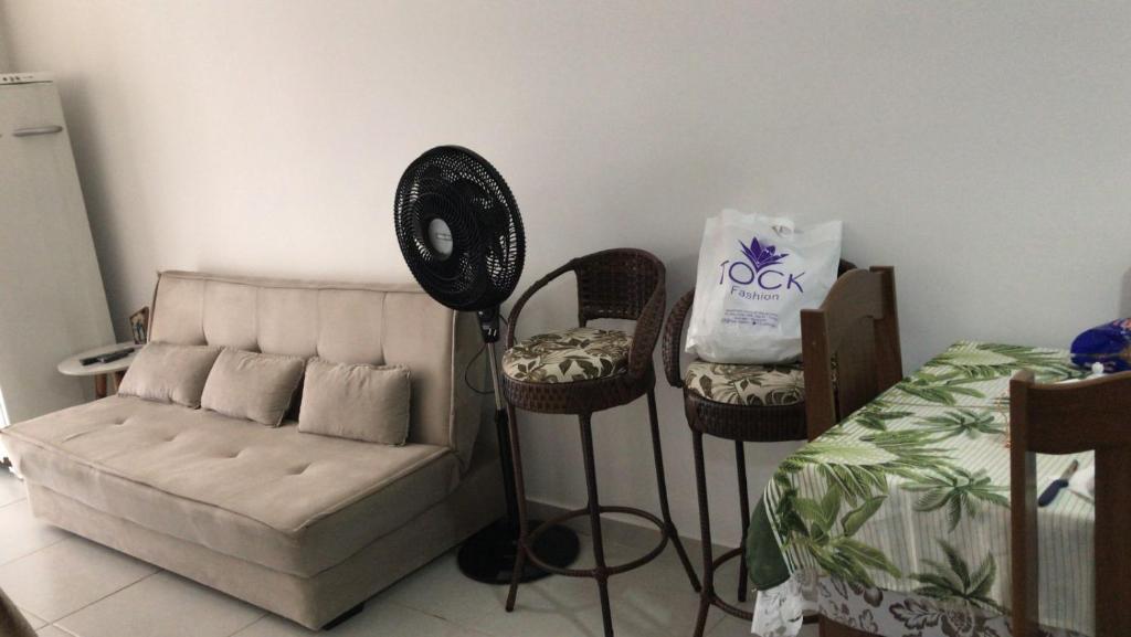 ein Wohnzimmer mit einem Sofa und einem Ventilator in der Unterkunft Apartamento no Condomínio da Fé in Cachoeira Paulista