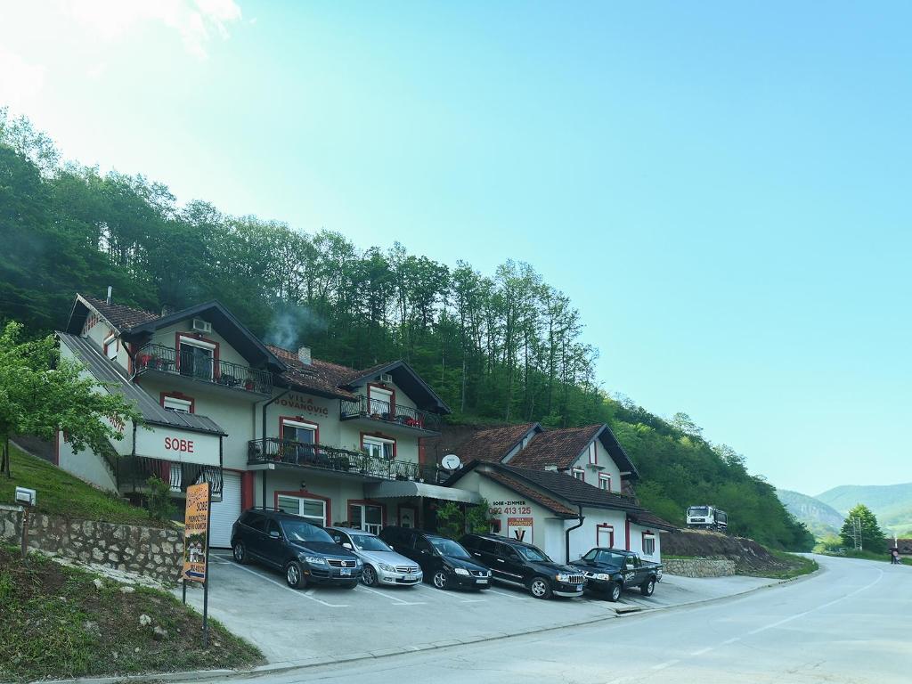 um grupo de carros estacionados em frente a um edifício em Vila Jovanovic em Ivanjica