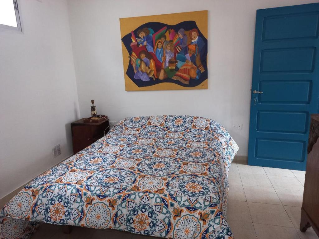 1 dormitorio con 1 cama y una pintura en la pared en Renacer en Salta en Salta