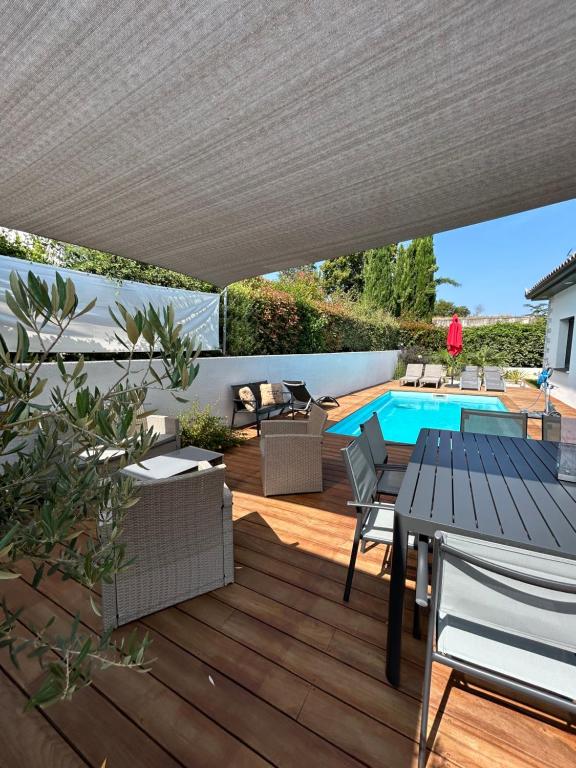 a patio with a table and chairs and a pool at STUDIO avec PISCINE in Carmaux